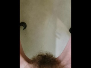 Disabled pixie pees in the tub sitting on a shower chair