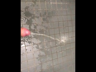 Messy pissing on the floor of a public toilet